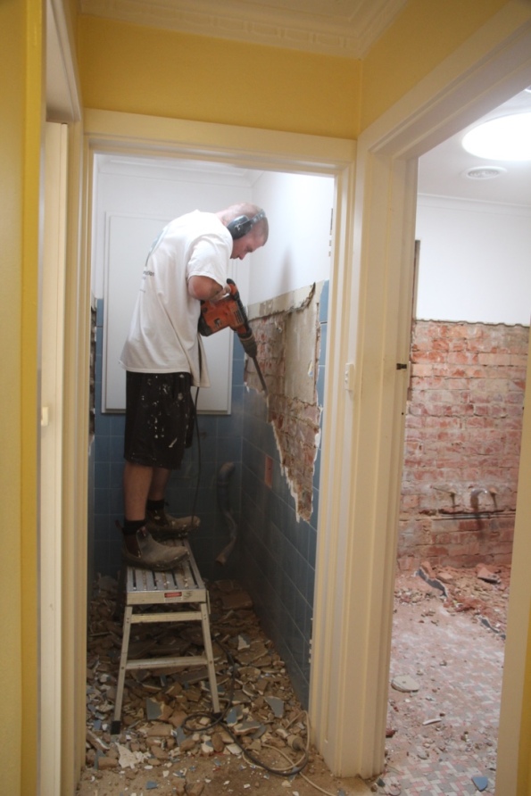 Cory jackhammers the toilet wall